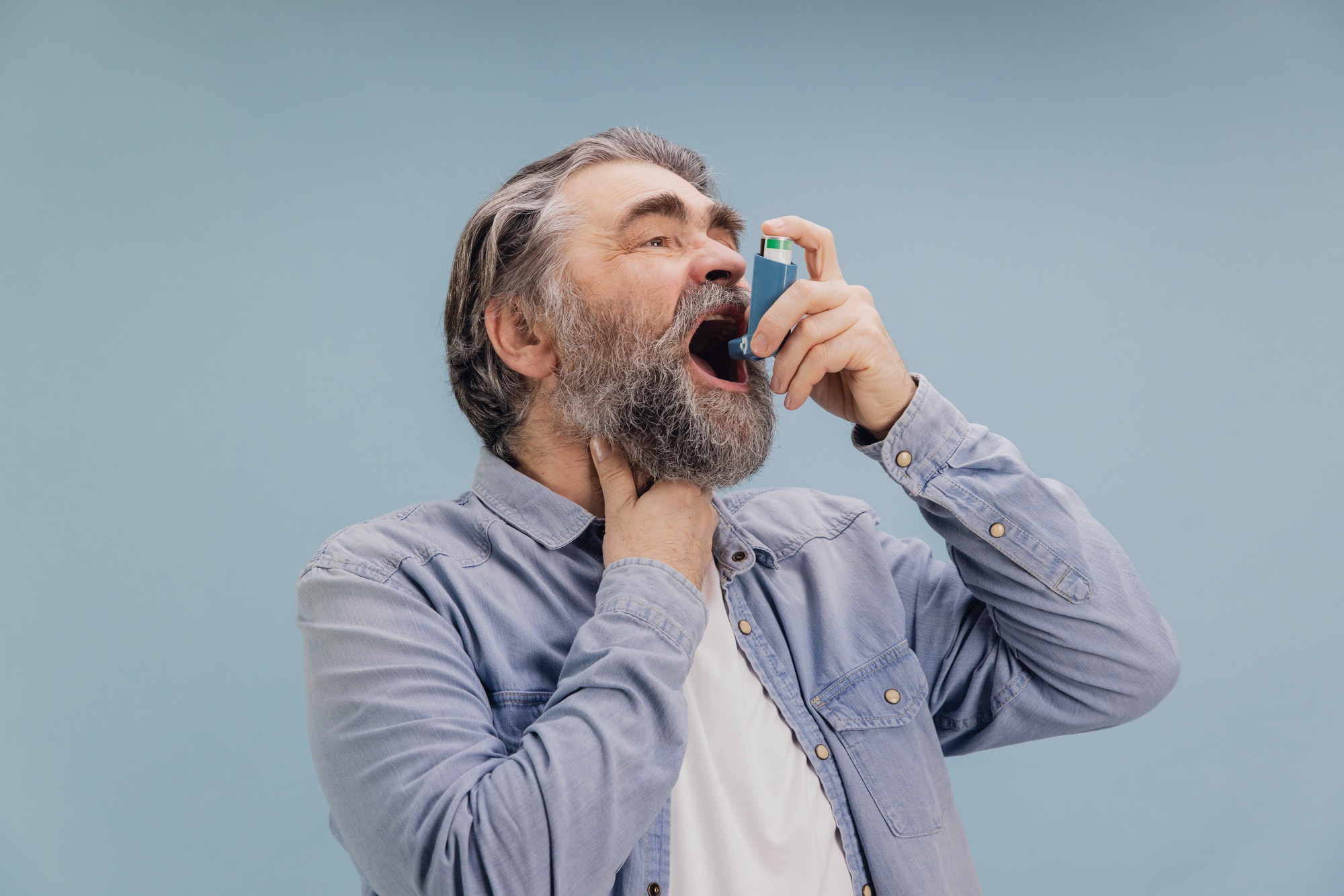 Senior Man Using Asthma Inhaler for Breathing Problems